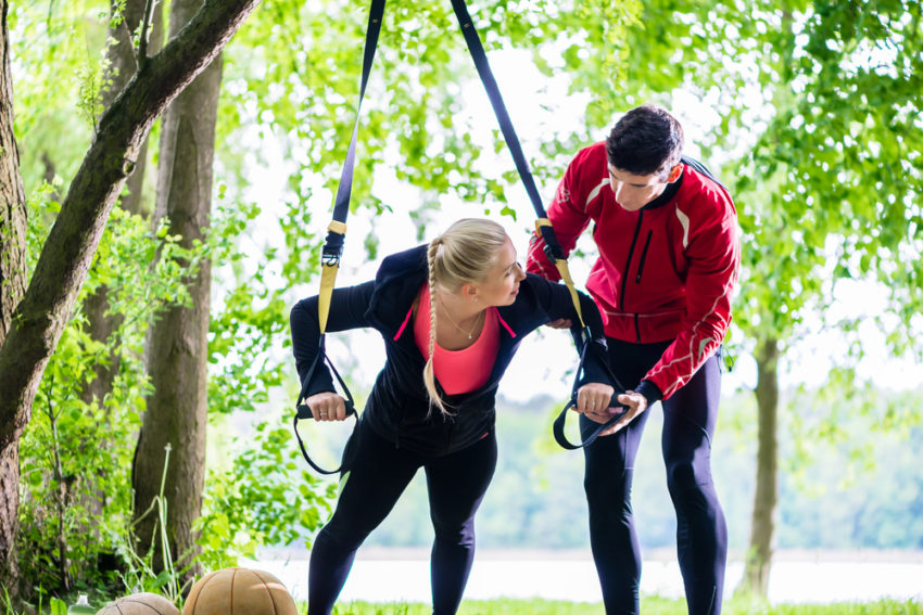 A woman and a man are exercising outdoors