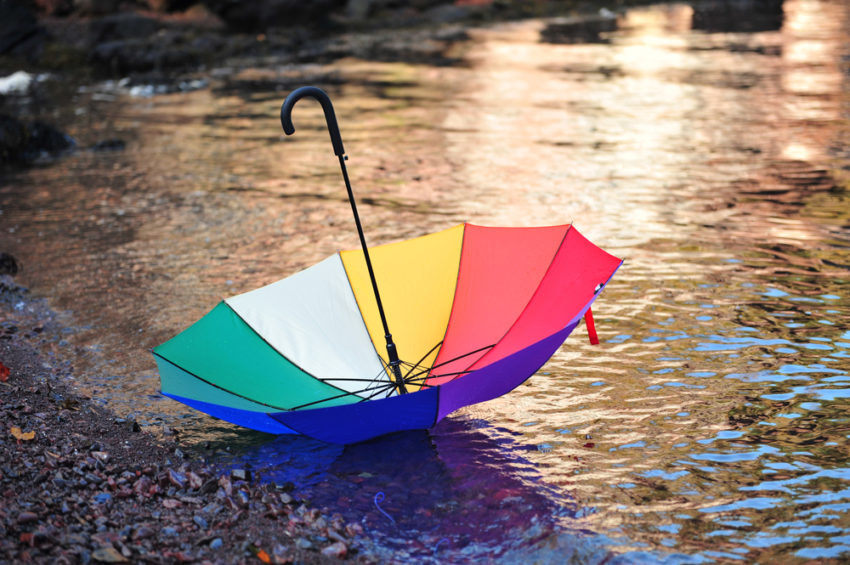A colourful umbrella lying next to a river (c) GracefulFoto / shutterstock