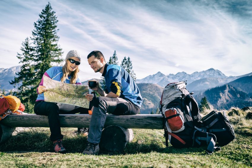 A couple sitting on a bench over a map. (c) Blazej Lyjak / shutterstock