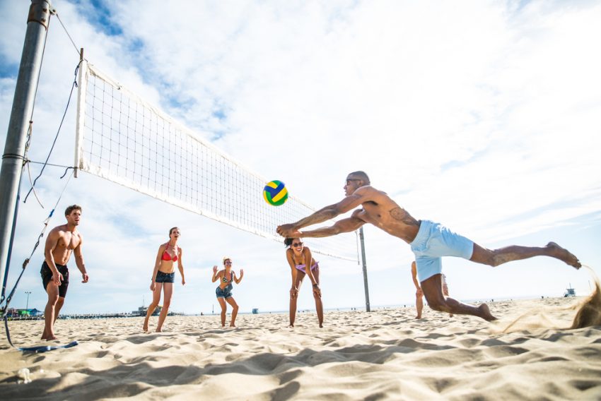 Freunde beim Beachvolleyball spielen (c) shutterstock.com/oneinchpunch