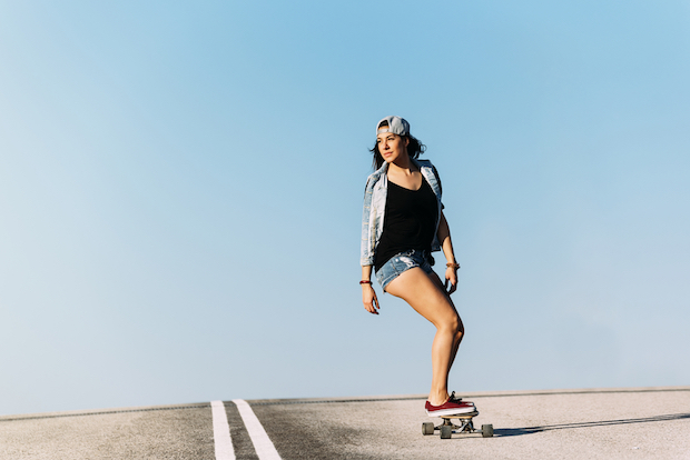 Junge Frau auf Longboard (c) shutterstock.com/santypan